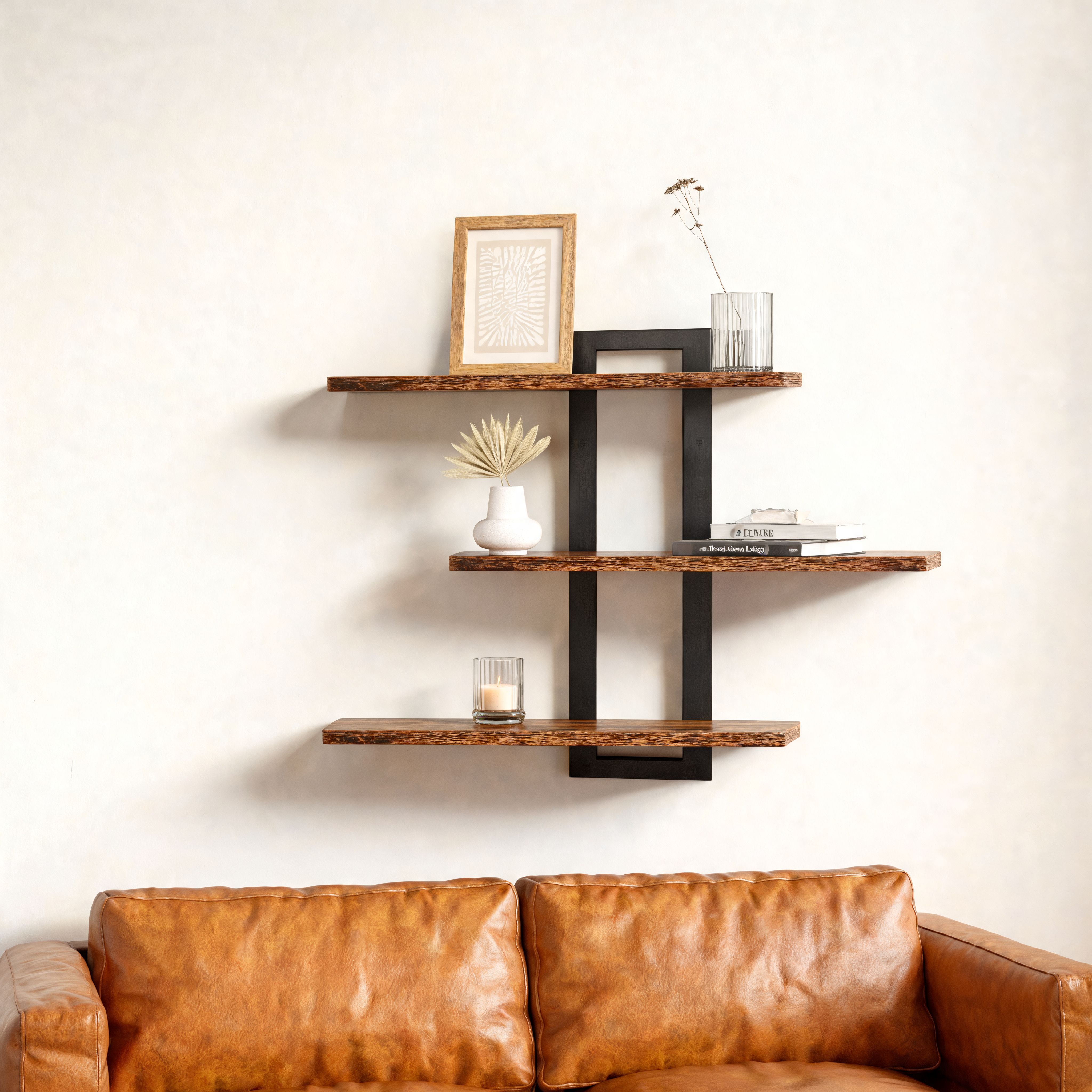 3-tier wall shelf with black frame above a leather sofa